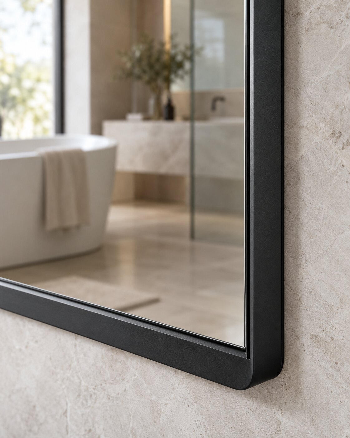 Close detail of the slim matte black aluminum mirror frame and reflection edge